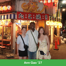 Three students standing in front of a takoyaki shop